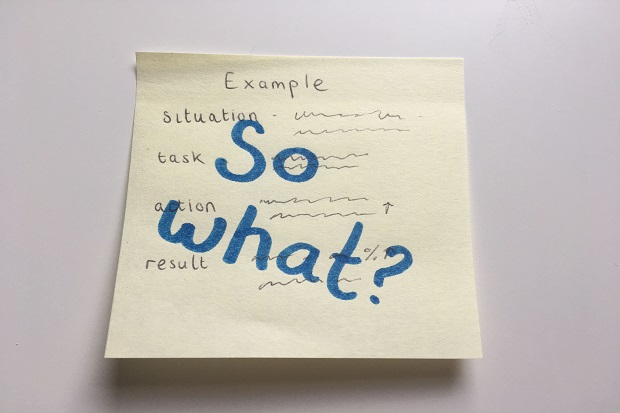 A close-up of a post-it note. At the top, someone has written ‘Example’ and ‘Situation, Task, Action, Result’ beneath it (spelling out STAR). In large, thick pen someone has written ‘So what?’ over the top. 